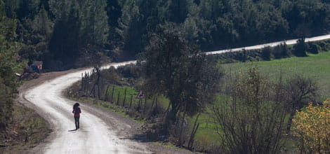 Woman walking along winding road